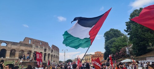 Bandiera della Palestina sventolla sopra il corteo No Rearm Europe