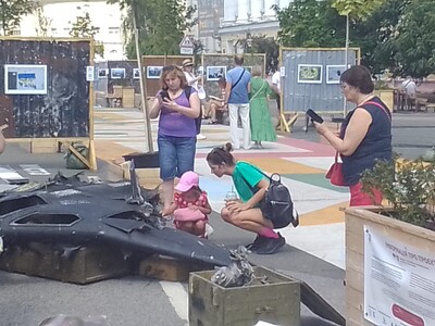 Una bambina guarda un drone abbatuto.