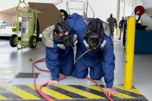 L'aviere Trace Fletcher e il sergente Cristian Martinez, addetti alla manutenzione dei sistemi carburante del 31st Maintenance Squadron, escono strisciando da un hangar durante l'esercitazione annuale con schiuma AFFF alla base aerea di Aviano, 29 aprile 2021. La schiuma AFFF è un agente estinguente utilizzato per spegnere gli incendi da combustibile liquido. L'utilizzo è a fini informativi e non costituisce avallo da parte del Dipartimento della Difesa degli Stati Uniti.