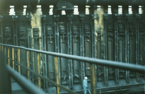 Foto 16 - Cokeria. Qui siamo sotto il piano coperchi; il fumo giallo contenente IPA cancerogeni fuoriesce liberamente (vedere parte superiore) e finisce sul piano coperchi investendo gli addetti visib