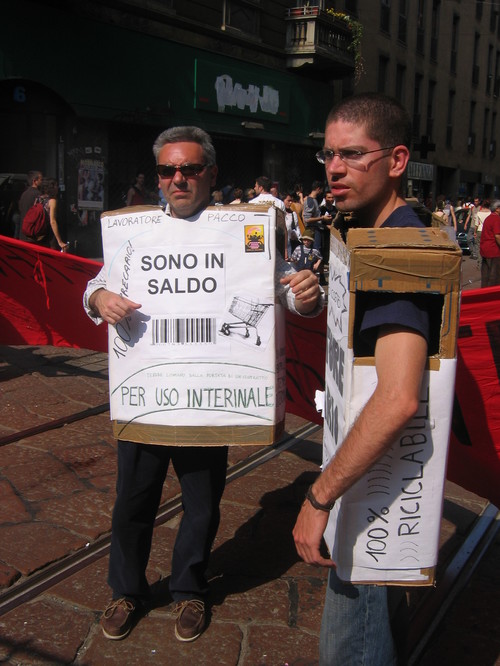 "Sono in saldo. Per uso interinale". Manifestanti travestiti da "lavoratori pacco", che si possono prendere e spostare a piacimento