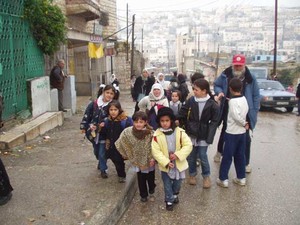 Membri dell'Ass. Christian Peacemaker Teams accompagnano alcuni bambini palestinesi a scuola attraversando con loro i territori israeliani.